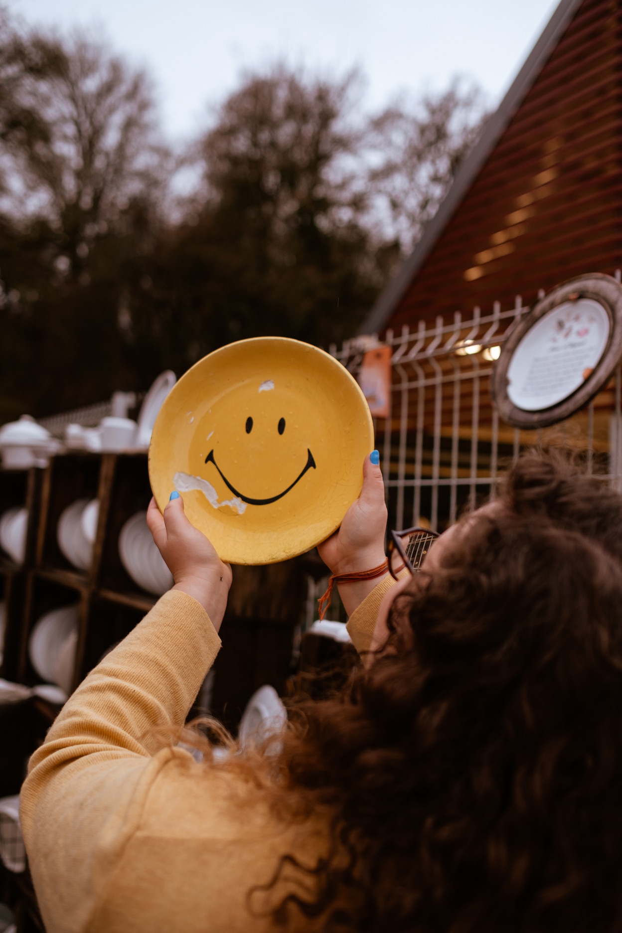 Cœur de tissu créatrice qui tiens une assiette jaune ébréchée faisant apparaitre un smiley heureux